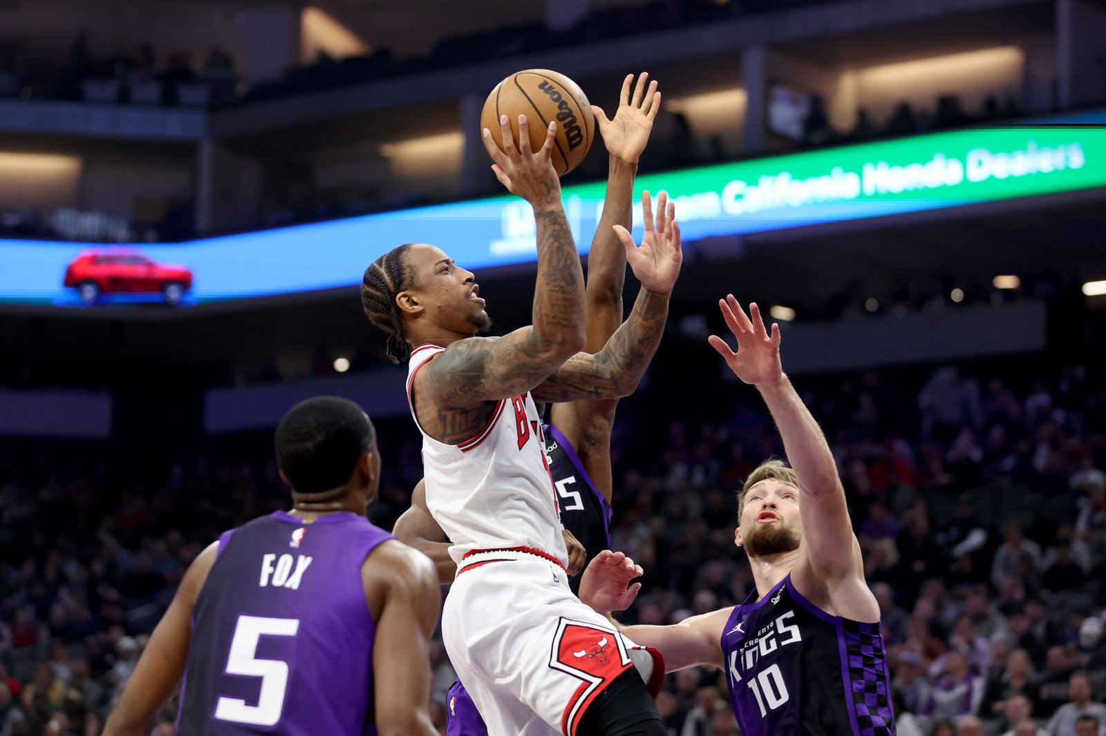 DeMar DeRozan #11 de Chicago Bulls contra De'Aaron Fox #5 y Domantas Sabonis #10 of the Sacramento Kings at Golden 1 Center on March 04, 2024 in Sacramento, (FotografíaEzra Shaw/Getty Images)