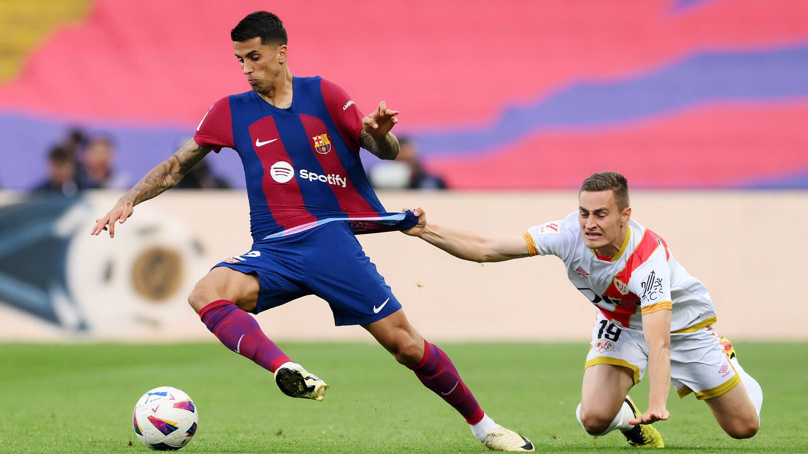 BARCELONA, SPAIN - MAY 19: Joao Cancelo of FC Barcelona is challenged by Jorge De Frutos of Rayo Vallecano during the LaLiga EA Sports match between FC Barcelona and Rayo Vallecano at Estadi Olimpic Lluis Companys on May 19, 2024 in Barcelona, Spain. (Photo by David Ramos/Getty Images)