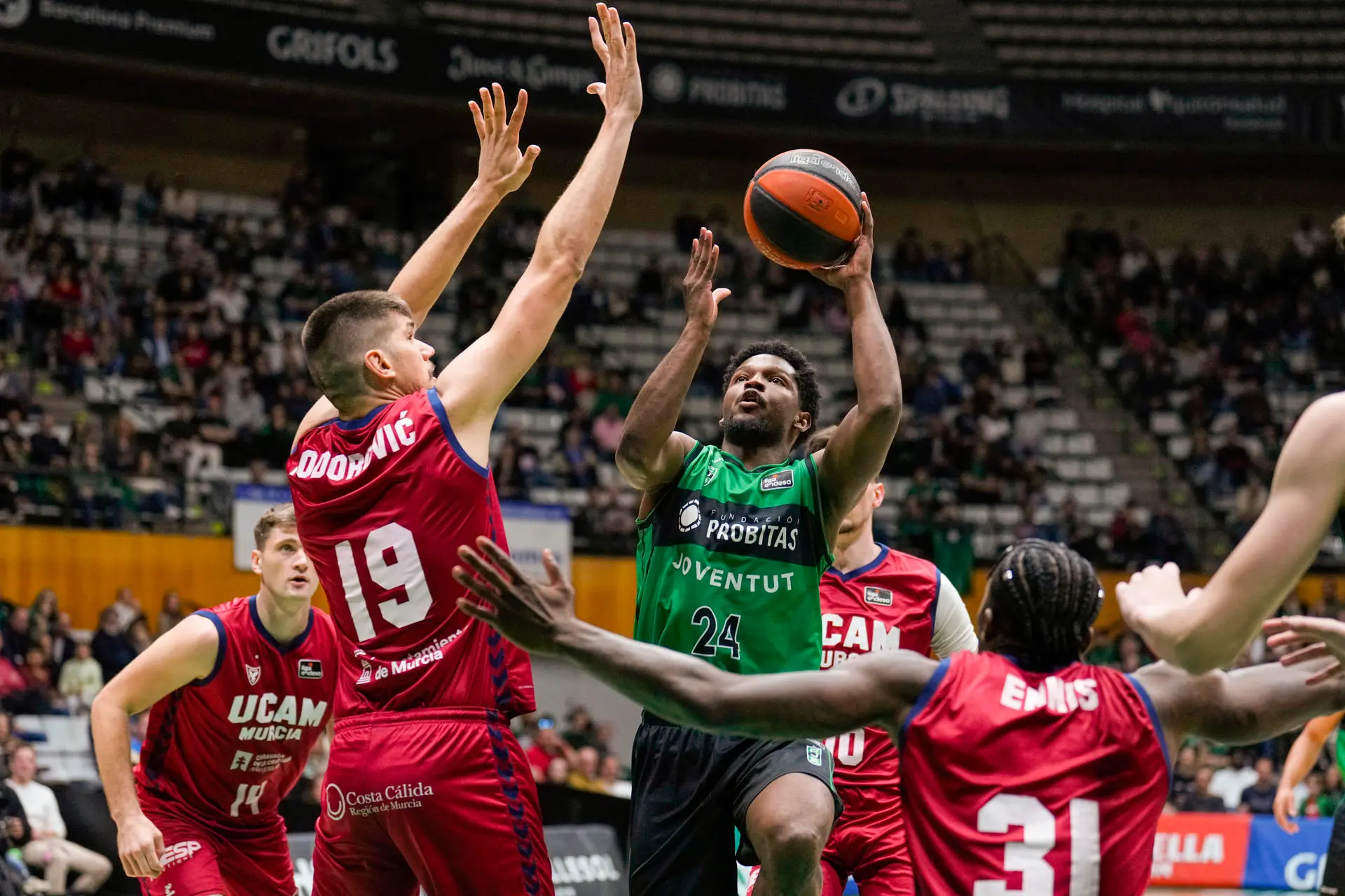 El base dominicano del Joventut Andrés Feliz (c) lanza ante el pívot montenegrino del UCAM Murcia Marko Todorovic (2i), en el partido de Liga Endesa de baloncesto que se disputó en el Olímpico de Badalona. EFE/Alejandro García