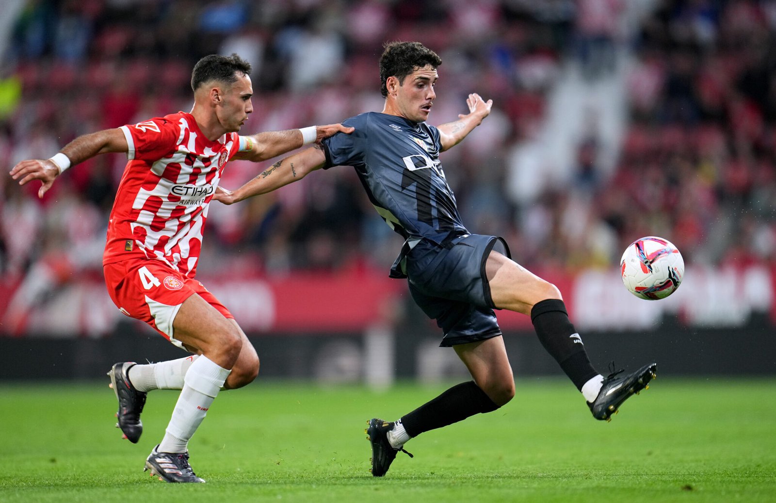 GIRONA, SPAIN - SEPTEMBER 25: Sergio Camello of Rayo Vallecano controls the ball whilst under pressure from Arnau Martinez of Girona FC during the La Liga EA Sports match between Girona FC and Rayo Vallecano at Montilivi Stadium on September 25, 2024 in Girona, Spain. (Photo by Aitor Alcalde/Getty Images)