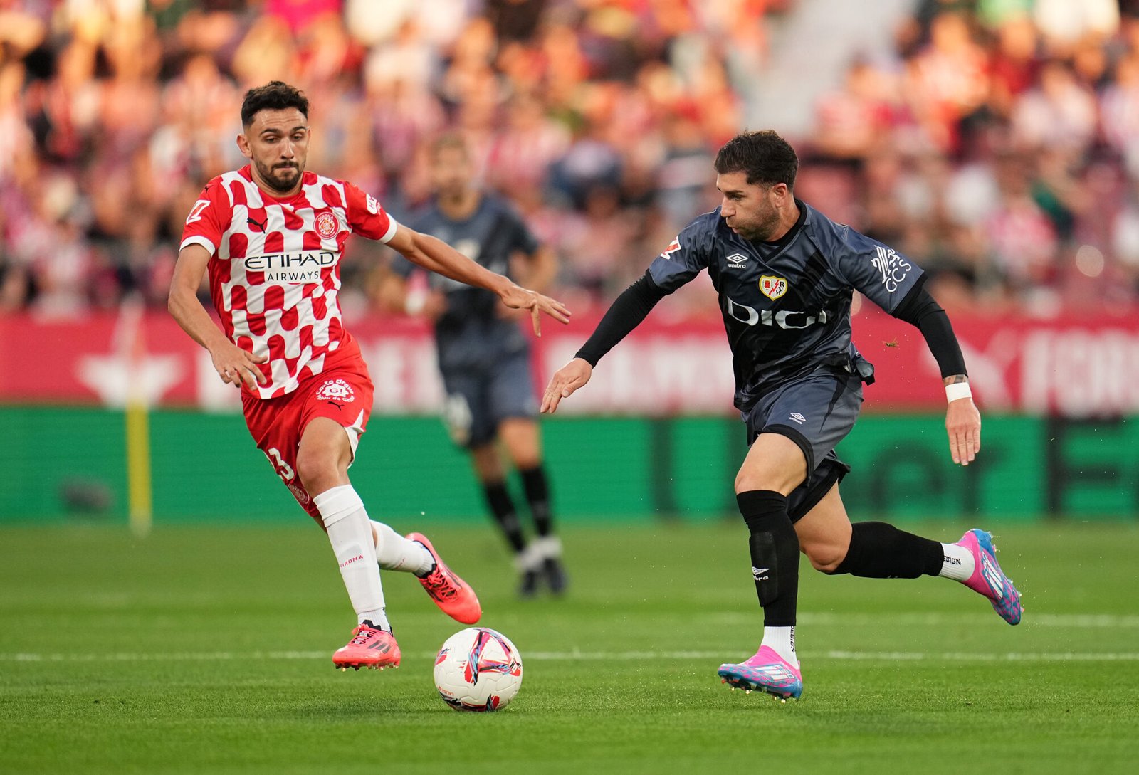 GIRONA, SPAIN - SEPTEMBER 25: Adri Embarba of Rayo Vallecano runs with the ball whilst under pressure from Ivan Martin of Girona FC during the La Liga EA Sports match between Girona FC and Rayo Vallecano at Montilivi Stadium on September 25, 2024 in Girona, Spain. (Photo by Aitor Alcalde/Getty Images)