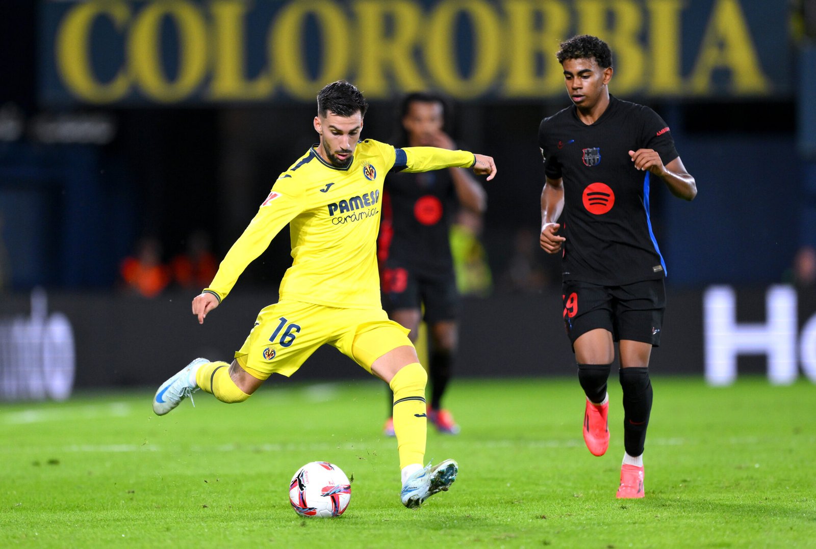 Alex Baena del Villarreal CF disparando bajo la presión de Lamine Yamal del FC Barcelona durante el partido de LaLiga entre el Villarreal CF y el FC Barcelona en el Estadio de la Ceramica