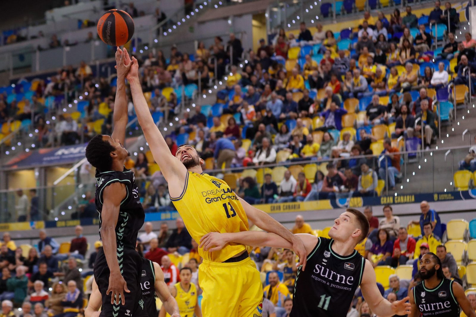 El pívot francés del Dreamland Gran Canaria Pierre Pelos (c) en acción ante los jugadores del Surne Bilbao Thijs De Ridder (d) y Alex Renfroe (i) este sábado, durante el partido de la jornada 14 de la Liga Endesa. EFE/ Elvira Urquijo A.