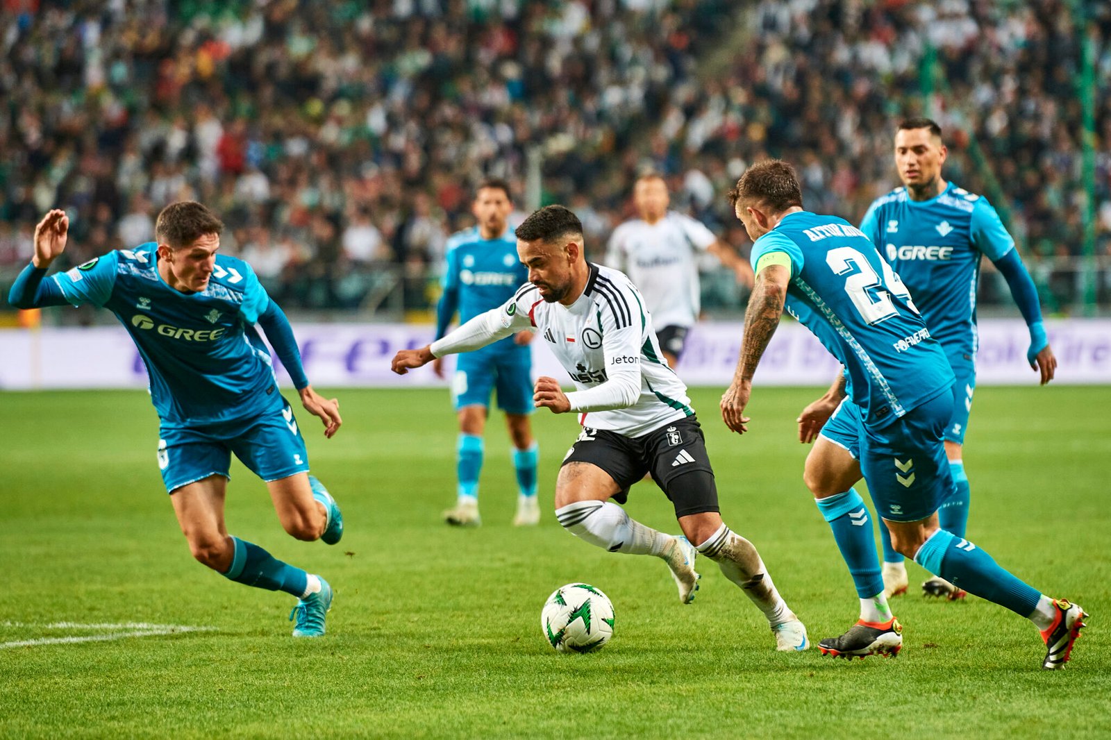 Luquinhas, del Legia de Varsovia, rodeado de jugadores del Real Betis.