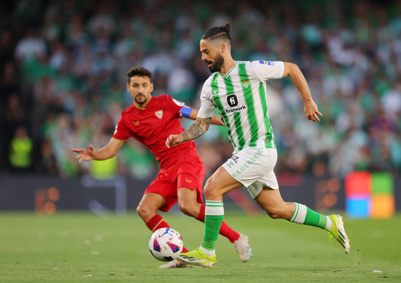 Isco del Real Betis corre con el balón mientras está bajo la presión de Jesús Navas del Sevilla FC durante el partido de LaLiga EA Sports entre el Real Betis y el Sevilla FC en el Estadio Benito Villamarin el 28 de abril de 2024 en Sevilla, España. (Foto de Fran Santiago/Getty Images)