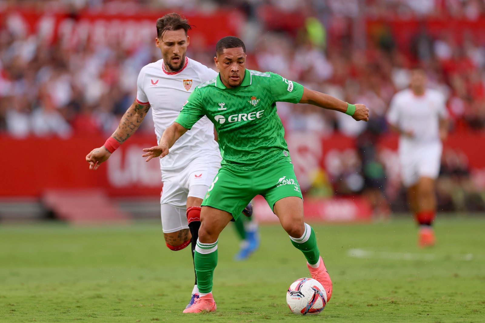 Vitor Roque del Real Betis corre con el balón bajo la presión de Nemanja Gudelj del Sevilla FC durante el partido de LaLiga entre el Sevilla FC y el Real Betis Balompie en el Estadio Ramón Sánchez Pizjuan el 6 de octubre de 2024 en Sevilla, España. (Foto de Fran Santiago/Getty Images)