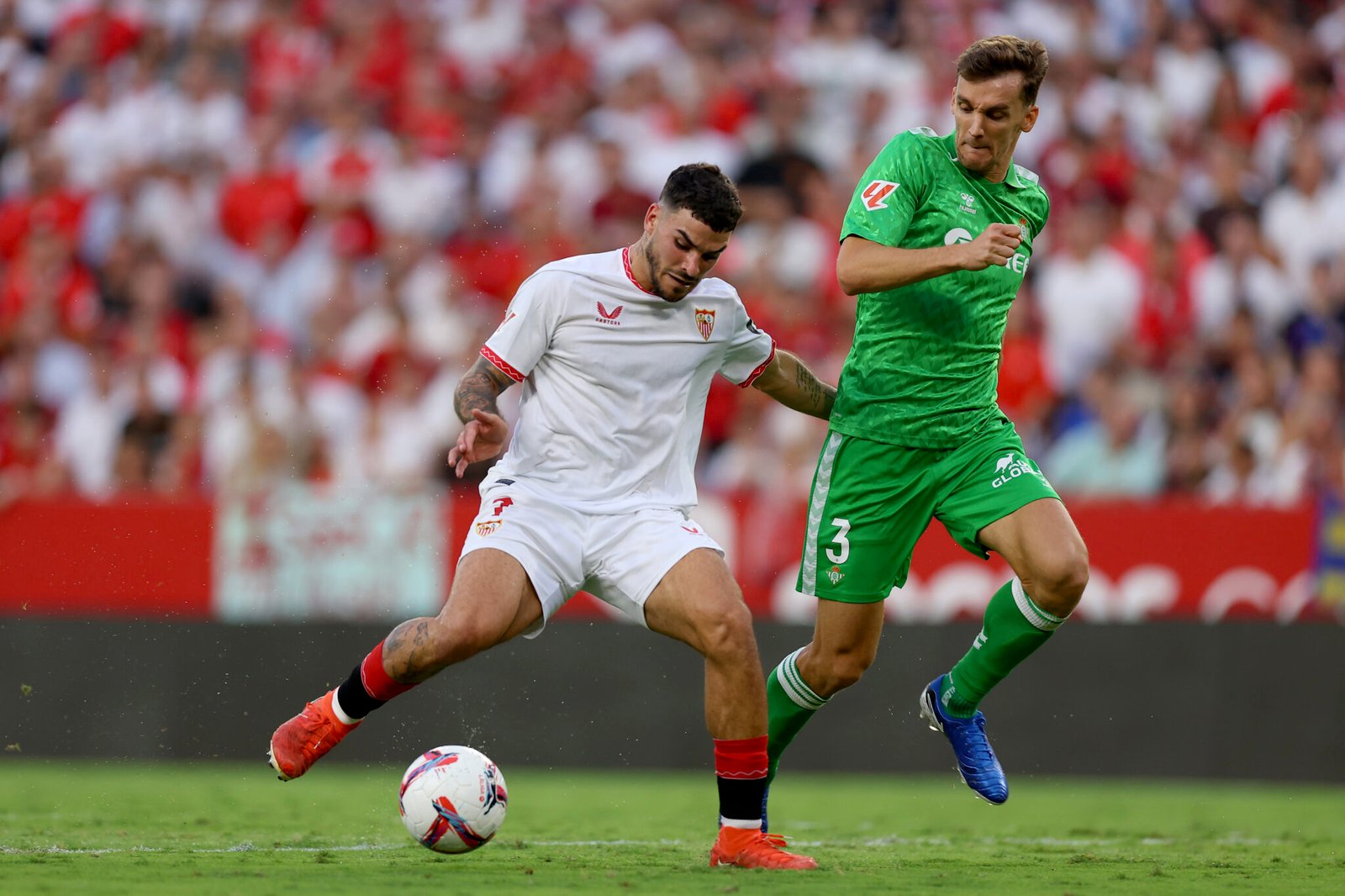 Isaac Romero del Sevilla FC controla el balón bajo la presión de Diego Llorente del Real Betis durante el partido de LaLiga entre el Sevilla FC y el Real Betis en el Estadio Ramón Sánchez Pizjuán el 6 de octubre de 2024 en Sevilla, España. (Foto de Fran Santiago/Getty Images)