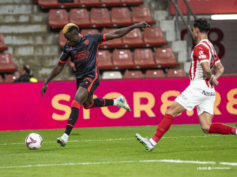 Soko tirando ante Diego Sánchez en la segunda parte entre el Sporting de Gijón contra el Huesca