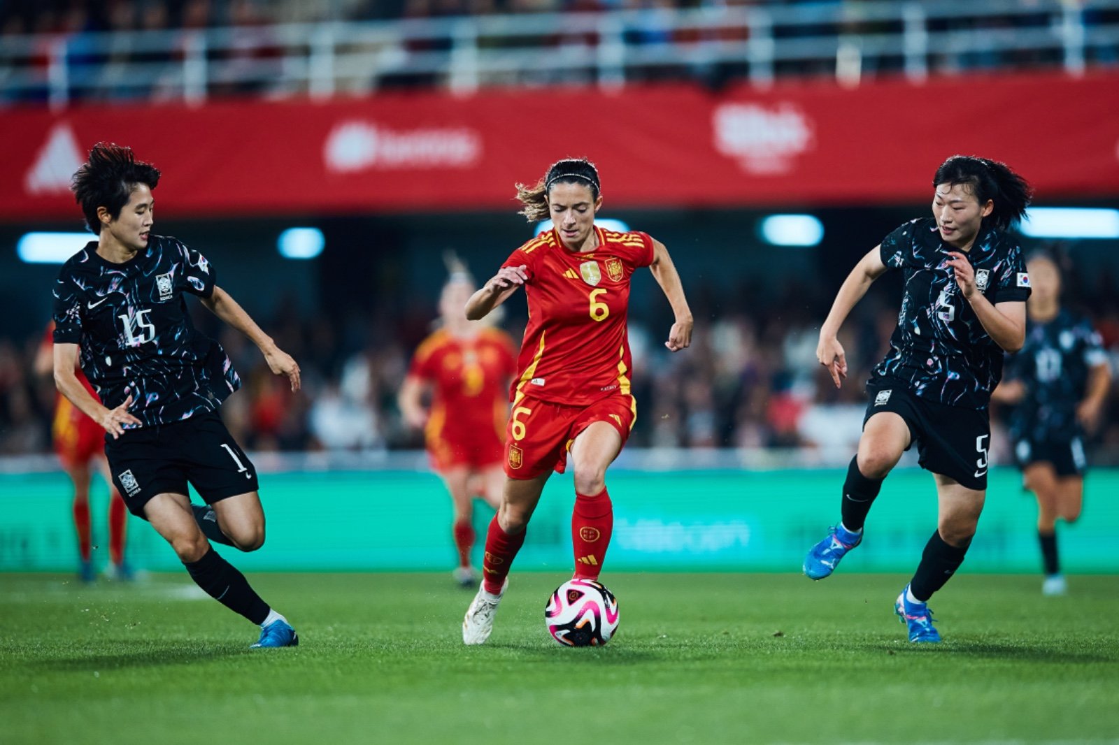 Aitana Bonmati conduce la pelota delante de 2 jugadoras coreanas. Fuente: Selección femenina de fútbol "X"