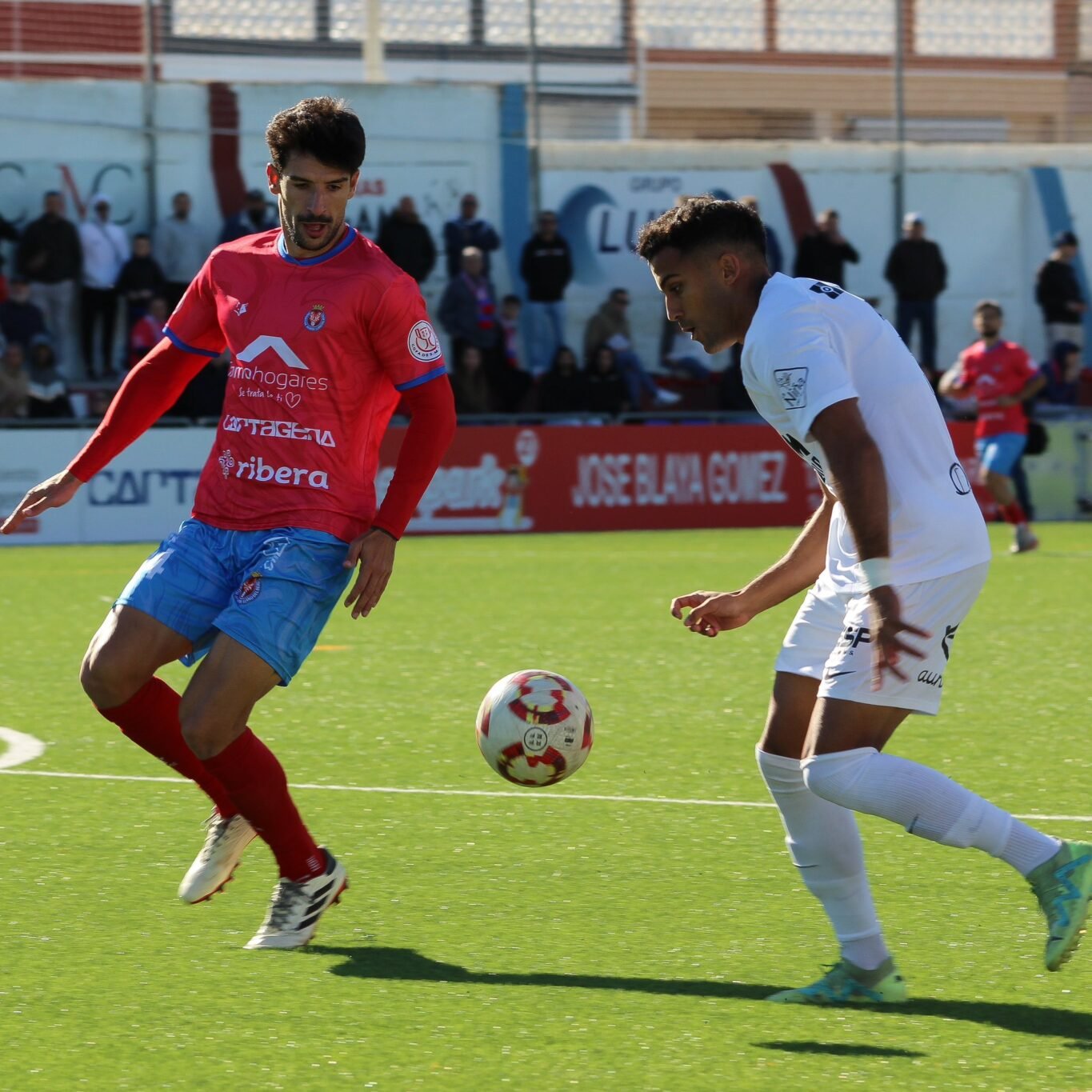 Amin, jugador del UCAM Murcia. intenta irse de un defensa de la Deportiva Minera. Fuente: UCAM Murcia CF "X"