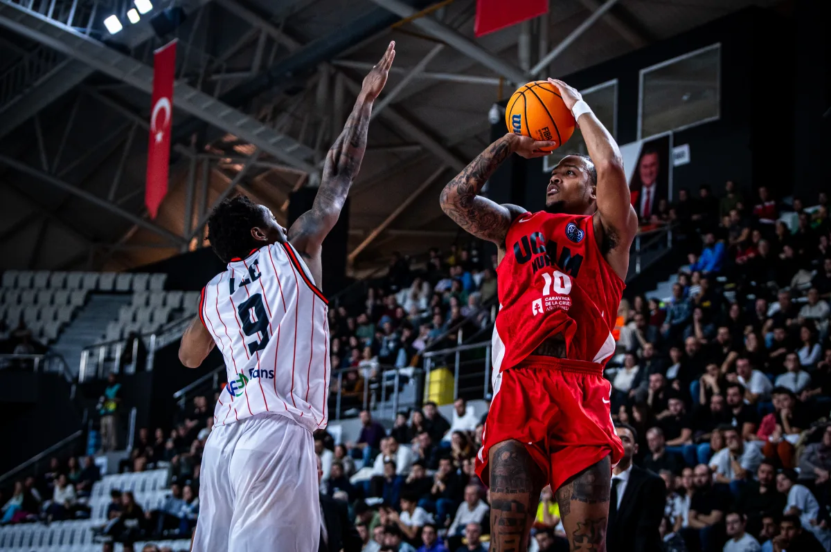 Troy Caupan ejecuta un tiro de 3 puntos delante de Saben Lee. Fuente: FIBA