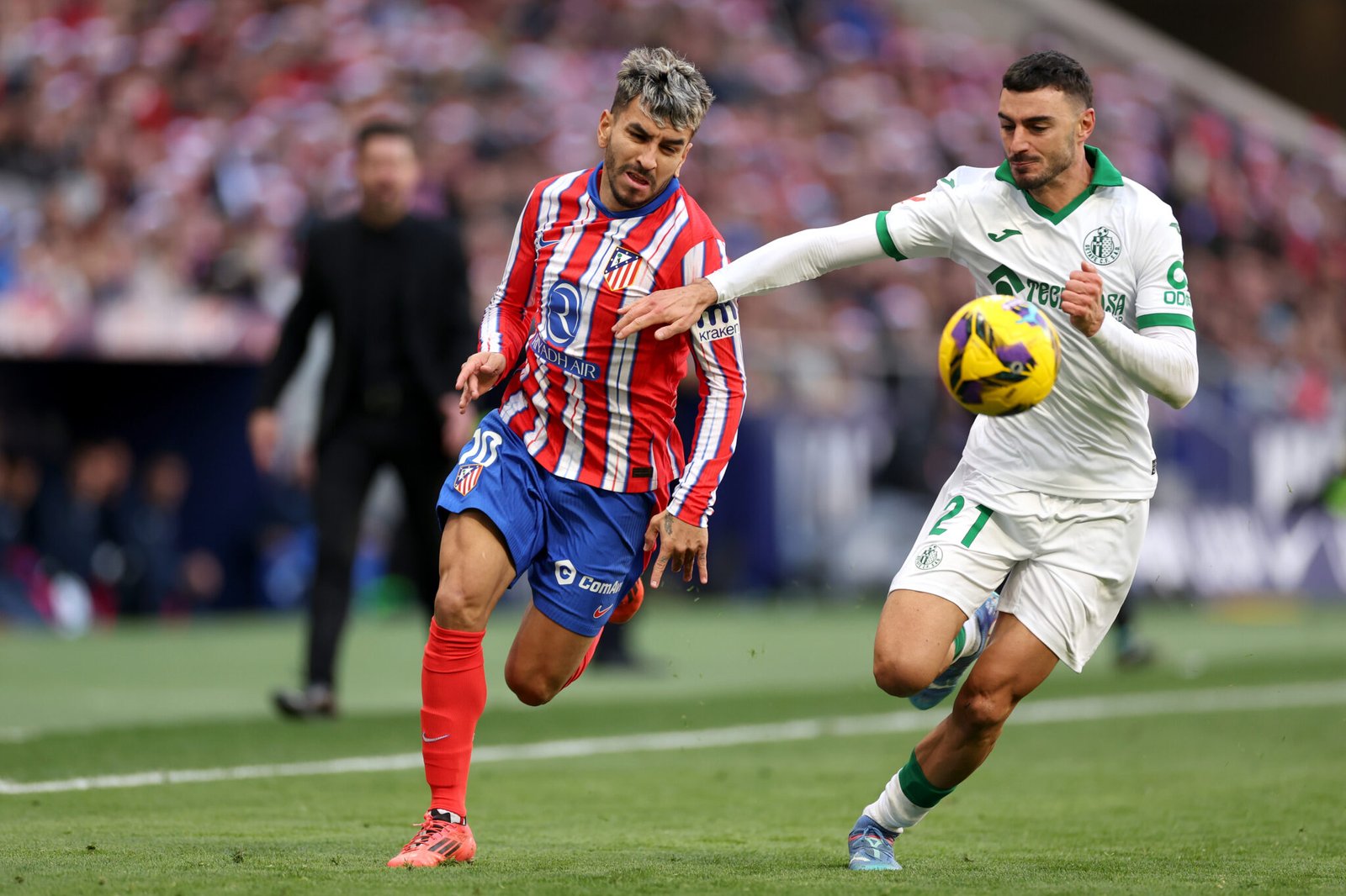 MADRID, ESPAÑA - 15 DE DICIEMBRE: Ángel Correa del Atlético de Madrid corre con el balón mientras es presionado por Juan Iglesias del Getafe CF durante el partido de LaLiga entre el Atlético de Madrid y el Getafe CF en el Riad Air Metropolitano el 15 de diciembre de 2024 en Madrid, España.  (Foto de Florencia Tan Jun/Getty Images)