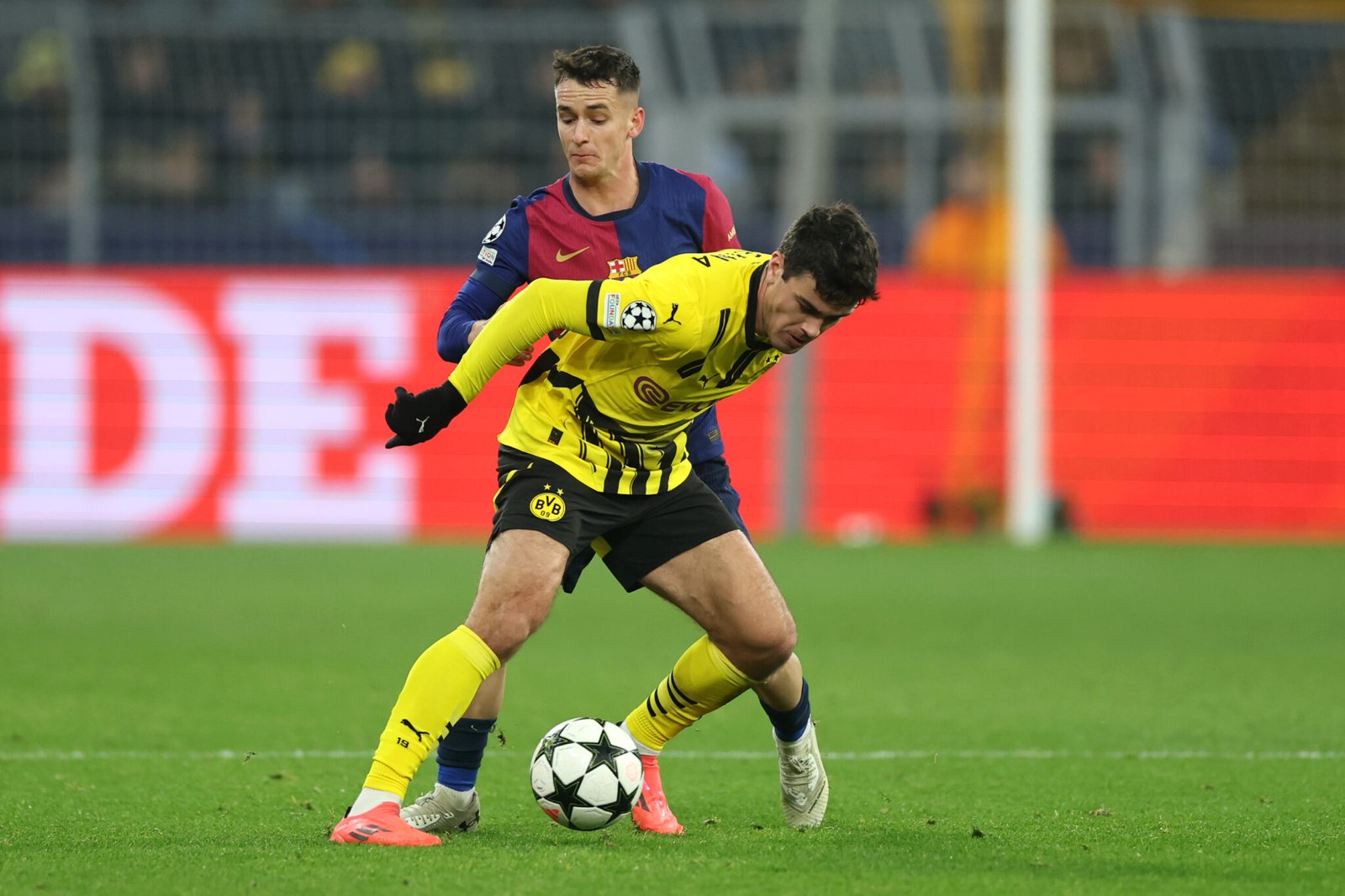 DORTMUND, GERMANY - DECEMBER 11: Giovanni Reyna of Borussia Dortmund is challenged by Marc Casado of FC Barcelona during the UEFA Champions League 2024/25 League Phase MD6 match between Borussia Dortmund and FC Barcelona at BVB Stadion Dortmund on December 11, 2024 in Dortmund, Germany. (Photo by Lars Baron/Getty Images)