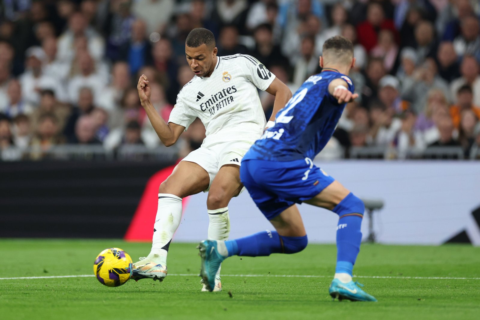 MADRID, ESPAÑA - 01 DE DICIEMBRE: Kylian Mbappé del Real Madrid remata bajo la presión de Domingos Duarte del Getafe CF durante el partido de LaLiga entre el Real Madrid CF y el Getafe CF en el Estadio Santiago Bernabéu el 01 de diciembre de 2024 en Madrid, España. (Foto de Florencia Tan Jun/Getty Images)