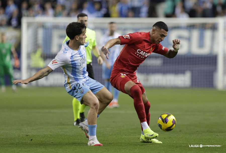 Kervin Arriaga aguantando el balón ante Nelson Monte en la primera parte entre el Málaga CF y el Real Zaragoza (Foto: vía La Liga Hypermotion / Redes Sociales `web`)