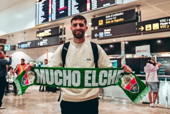 Pejiño posa con una bufanda del Elche en su llegada al aeropuerto. Foto: Elche CF.