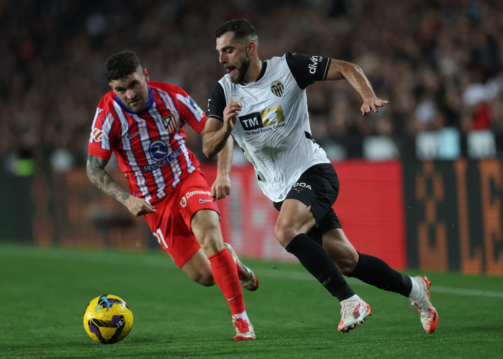 VALENCIA, ESPAÑA - 22 DE FEBRERO: Luis Rioja del Valencia CF corre con el balón mientras es presionado por Giuliano Simeone del Atlético de Madrid durante el partido de LaLiga entre el Valencia CF y el Atlético de Madrid en el Estadio Mestalla el 22 de febrero de 2025 en Valencia, España. (Foto de Clive Brunskill/Getty Images)