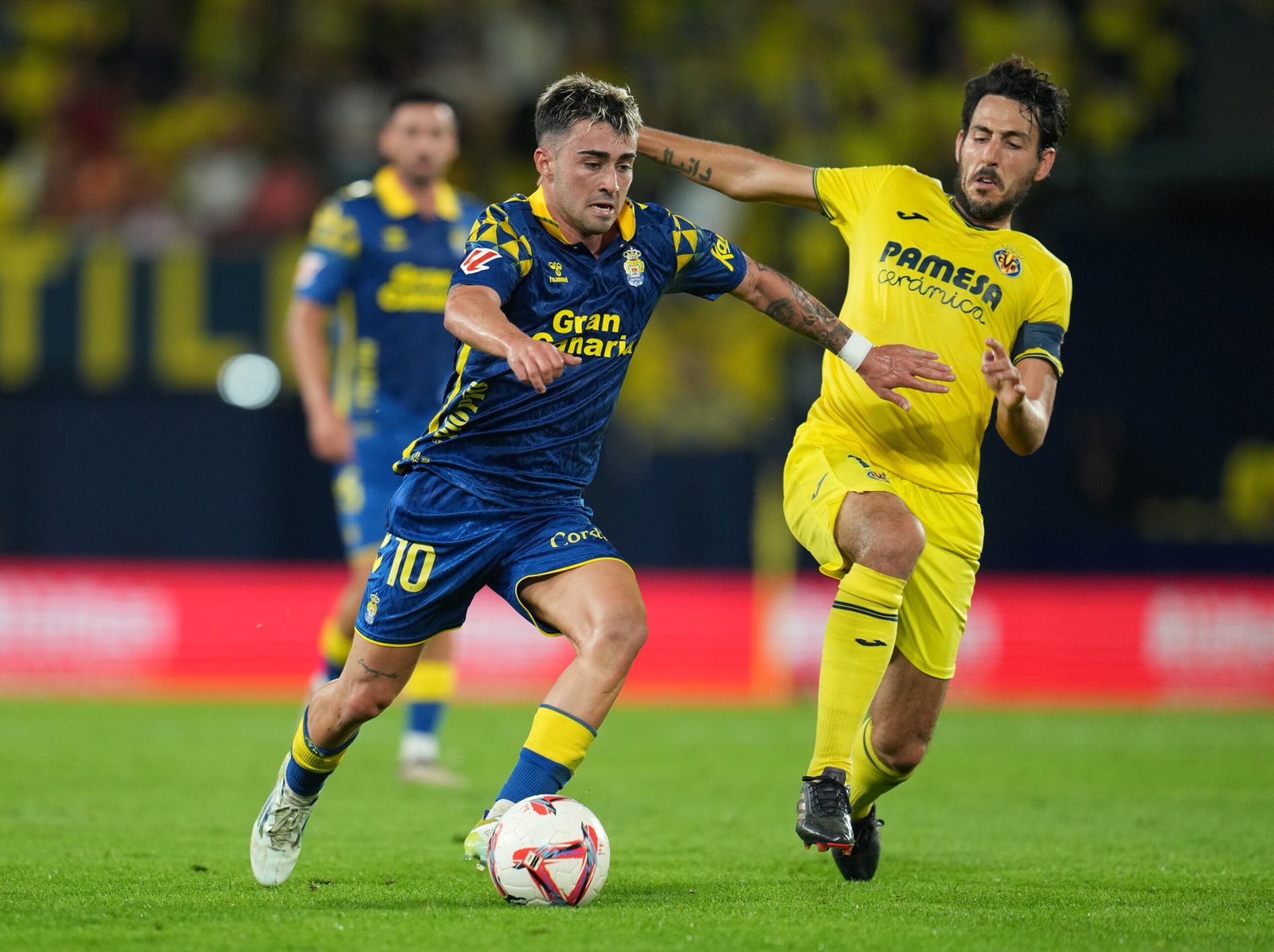 Alberto Moleiro de UD Las Palmas corre con el balón mientras está bajo la presión de Daniel Parejo de Villarreal CF durante el partido de LaLiga entre Villarreal CF y UD Las Palmas en el Estadio de la Cerámica el 30 de septiembre de 2024 en Villarreal, España.