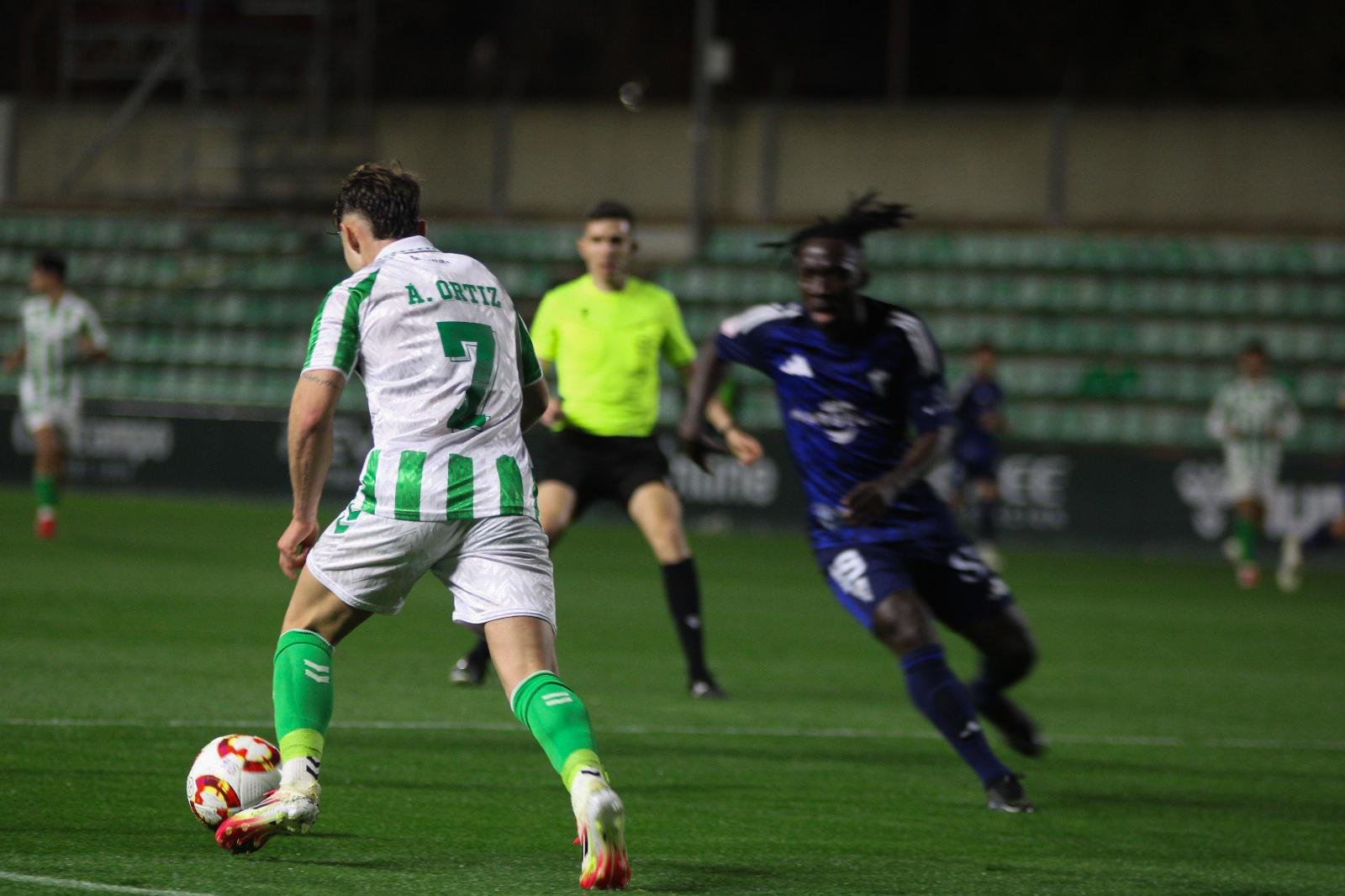 SEVILLA, ESPAÑA - Ángel Ortiz controla el balón en el partido entre el Betis Deportivo y el Marbella FC delante de Ernest Ohemeng (Foto: Irene Chaves)