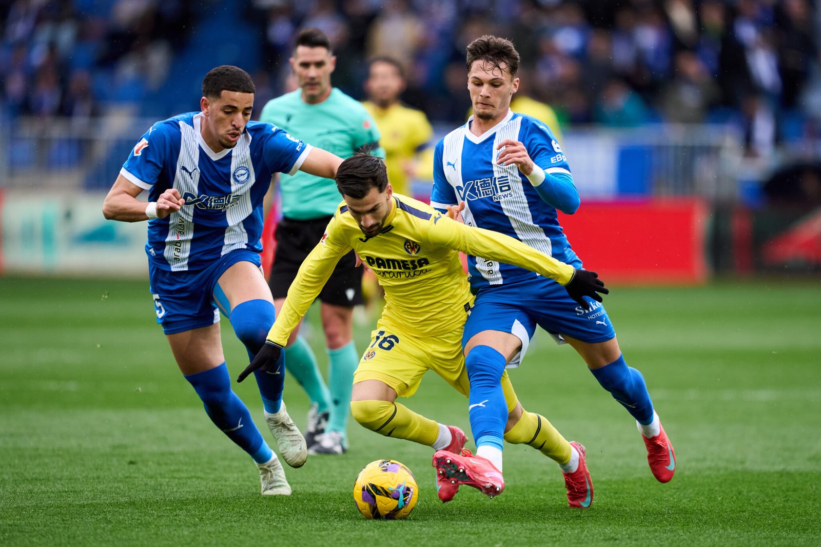 Alex Baena del Villarreal FC se duelo por el balón con Abdel Abqar y Pau Cabanes del Deportivo Alaves durante el partido de LaLiga entre el Deportivo Alaves y el Villarreal CF 