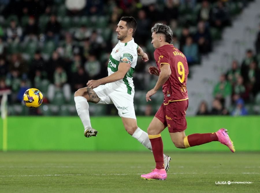 Pedro Bigas, jugador del Elche CF, despejando el balón ante Arana, jugador del Racing de Santander.