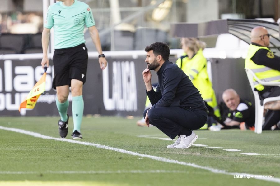 Guillermo Fernández Romo, entrenador del FC Cartagena, en cuclillas en el partido contra el Racing de Santander. Fuente: LaLiga vía web